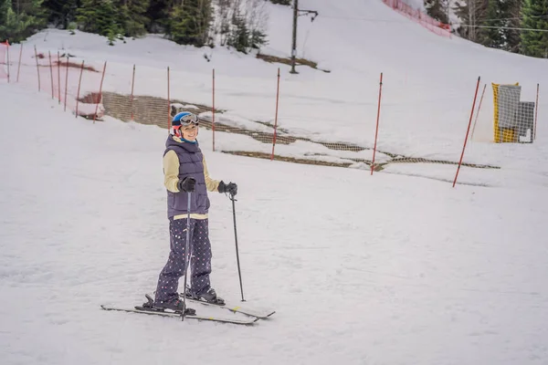Η μαμά και ο γιος μαθαίνουν σκι με έναν δάσκαλο. Ενεργό παιδί νηπίων με κράνος ασφαλείας, γυαλιά και κοντάρια. Αγώνας σκι για μικρά παιδιά. Χειμερινό άθλημα για την οικογένεια. Μαθήματα σκι για παιδιά στην αλπική σχολή — Φωτογραφία Αρχείου