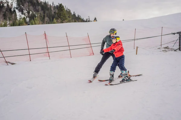 Chlapec učí lyžovat, trénovat a poslouchat svého lyžařského instruktora na sjezdovce v zimě — Stock fotografie