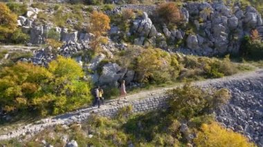 Hava görüntüsü. Dron, Karadağ 'daki Kosmach Kalesi' ne doğru giden bir erkek kadın ve oğullarının ailesini izliyor. Avusturyalılar tarafından savunma amaçlı inşa edilmiş eski bir kale.