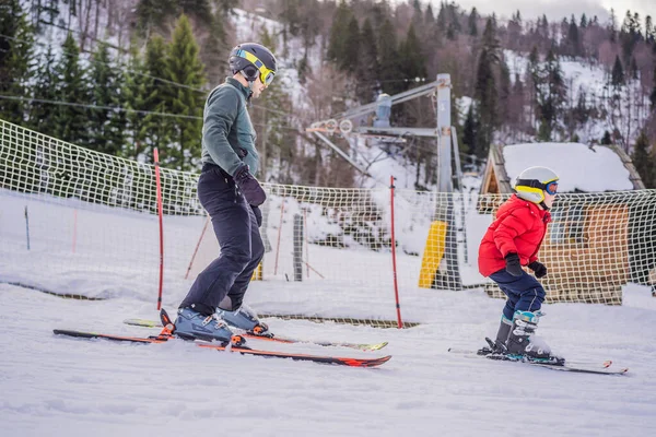 Мальчик учится кататься на лыжах, тренироваться и слушать своего лыжного инструктора на склоне зимой — стоковое фото