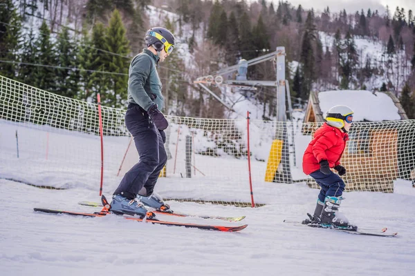 Pojken lär sig att åka skidor, träna och lyssna på sin skidlärare i backen på vintern — Stockfoto