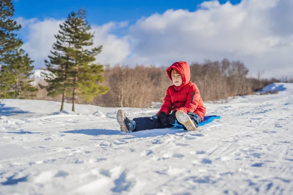 행복 하 고 긍정적인 소년 야외, 겨울 썰매와 추운 날씨를 즐기는 활동 개념을 재미 있는 — 스톡 사진