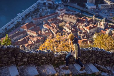 Genç turist kadın Karadağ 'ın Kotor Körfezi manzarasının keyfini çıkarıyor. Kotor Eski Şehir Merdiveni Kotor Kalesi Yürüyüş Yolu. Hava aracı görünümü