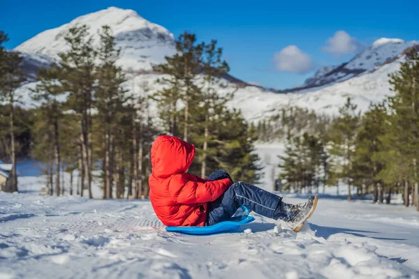 Menino pequeno feliz e positivo apreciando trenó e frio tempo ao ar livre, conceito de atividade divertida de inverno — Fotografia de Stock