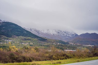 Dağlar karla ve yeşilliklerle kaplı.