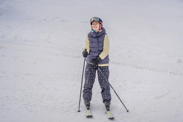 스키를 배우는 여성. 산속의 눈덮인 길에서 스키를 타는 젊은 여자 — 스톡 사진