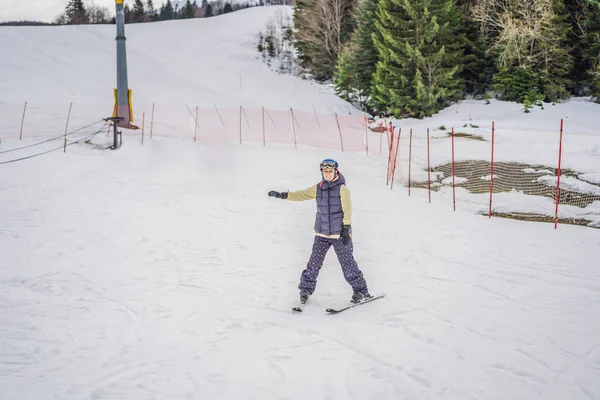 Femme apprenant à skier. Jeune femme skiant sur une route enneigée dans les montagnes — Photo