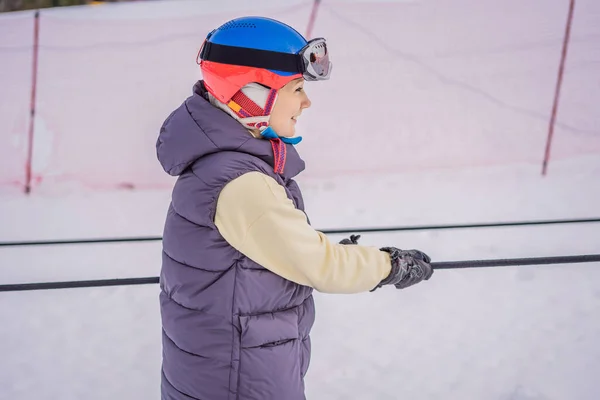 Woman skier climbs a mountain on a ski lift for beginners — Stock Photo, Image