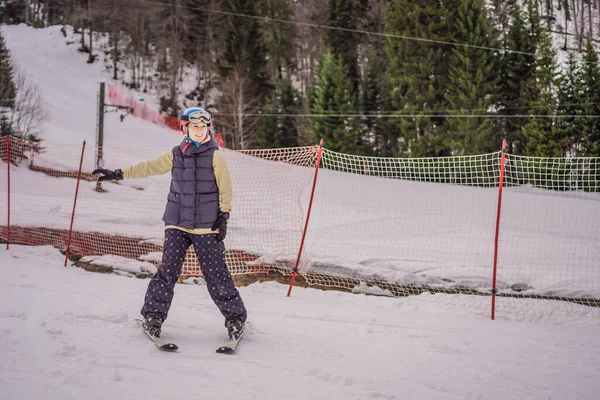 Femme apprenant à skier. Jeune femme skiant sur une route enneigée dans les montagnes — Photo