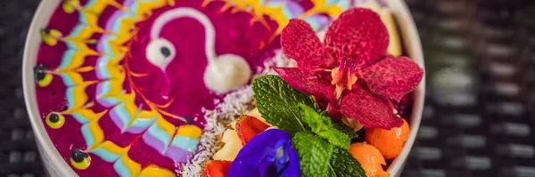 BANNER, LONG FORMAT Pequeno-almoço tropical saudável, smoothie bowl com frutas tropicais, decorado com um padrão de iogurte colorido com açafrão e espirulina. Também é decorado com frutas, flores — Fotografia de Stock