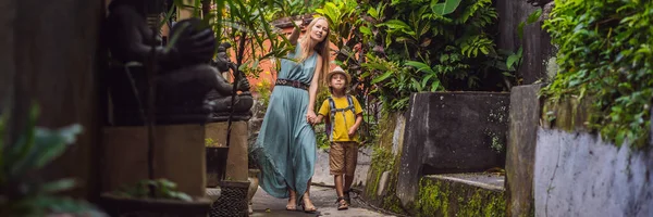 Mother and son tourists in Bali walks along the narrow cozy streets of Ubud. Bali is a popular tourist destination. Travel to Bali concept. Traveling with children concept BANNER, LONG FORMAT — Stock Photo, Image