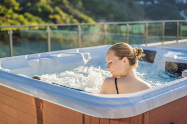 Genç kaygısız mutlu kadının portresi jakuzide rahatlayarak yeşil büyük dağların arka planında mutlu bir tatil hayatı yaşıyor.