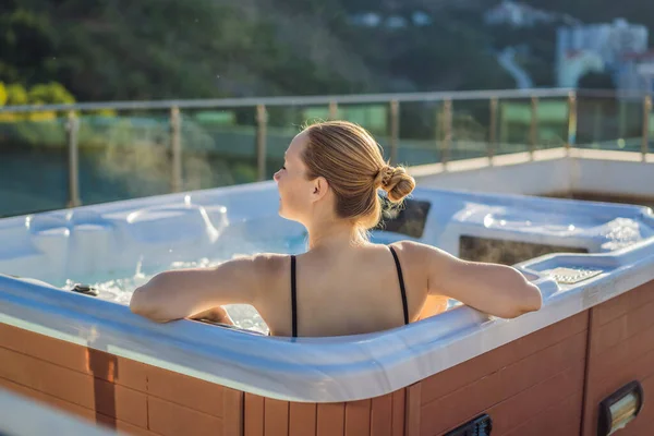 Retrato de la joven despreocupada feliz mujer sonriente relajarse en la bañera de hidromasaje durante el disfrute de la vida feliz viaje momento de vacaciones en el fondo de grandes montañas verdes — Foto de Stock