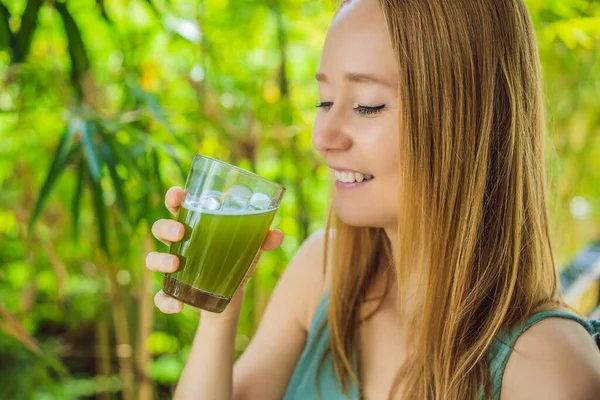 Wanita muda minum Juice Celery, Minuman Sehat, sekelompok seledri pada latar belakang kayu — Stok Foto