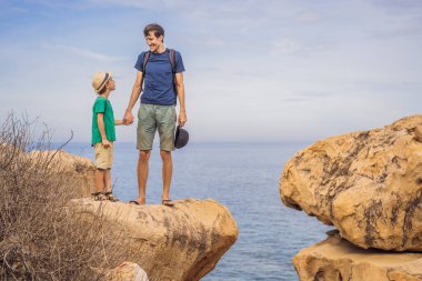 Baba ve oğlu bir kayanın üstünde. Yurtiçi tatil kavramı