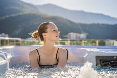 Genç kaygısız mutlu kadının portresi jakuzide rahatlayarak yeşil büyük dağların arka planında mutlu bir tatil hayatı yaşıyor.