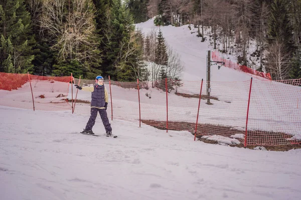 Kvinnan lär sig att åka skidor. Ung kvinna skidåkning på en snöig väg i bergen — Stockfoto