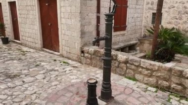 Eski Kotor kasabasında eski bir su pompası. Karadağ 'a seyahat. Akıllı telefondan vurulmuş.