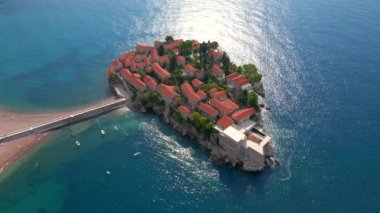 Hava görüntüsü. Sveti Stefan adasının yavaş çekim videosu. Budva şehrinin yakınlarında ünlü bir turistik mekan. Karadağ 'a Seyahat