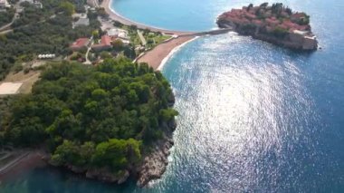 Hava görüntüsü. Sveti Stefan adasının yavaş çekim videosu. Budva şehrinin yakınlarında ünlü bir turistik mekan. Karadağ 'a Seyahat