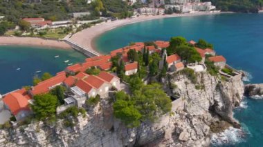 Hava görüntüsü. Sveti Stefan adasının yavaş çekim videosu. Budva şehrinin yakınlarında ünlü bir turistik mekan. Karadağ 'a Seyahat