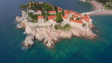 Hava görüntüsü. Sveti Stefan adasının yavaş çekim videosu. Budva şehrinin yakınlarında ünlü bir turistik mekan. Karadağ 'a Seyahat