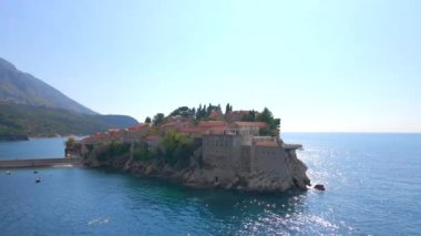 Hava görüntüsü. Sveti Stefan adasının yavaş çekim videosu. Budva şehrinin yakınlarında ünlü bir turistik mekan. Karadağ 'a Seyahat