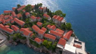 Hava görüntüsü. Sveti Stefan adasının yavaş çekim videosu. Budva şehrinin yakınlarında ünlü bir turistik mekan. Karadağ 'a Seyahat