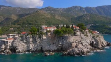 Hava görüntüsü. Sveti Stefan adasının yavaş çekim videosu. Budva şehrinin yakınlarında ünlü bir turistik mekan. Karadağ 'a Seyahat