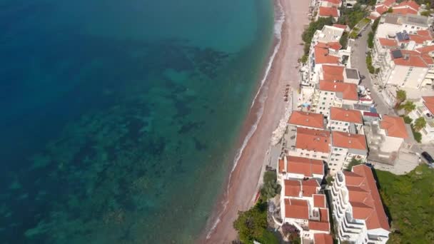 Tiro aéreo. Vídeo em câmara lenta da ilha Sveti Stefan. Famosa localização turística perto da cidade de Budva. Viajar para Montenegro conceito — Vídeo de Stock