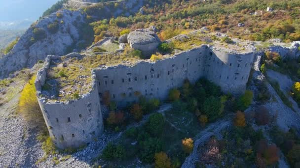 Letecký záběr. následuje muže, jak sestupuje z kopce směrem od pevnosti Kosmach v Černé Hoře. Stará pevnost postavená Rakušany jako obranná stavba a vyhlídkové místo — Stock video