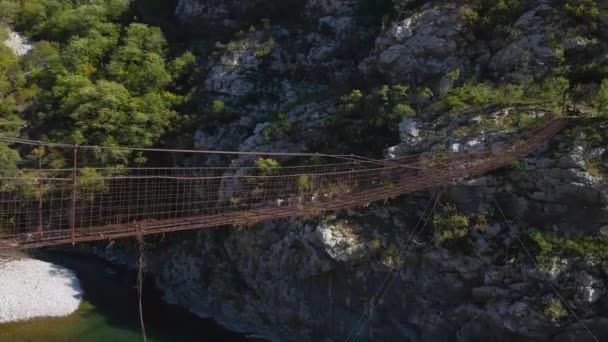 Vídeo aéreo. Uma velha ponte de corda de metal através do desfiladeiro do rio Moraca em Montenegro — Vídeo de Stock