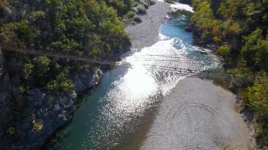 Hava videosu. Karadağ 'daki Moraca nehri kanyonu üzerinde eski metal bir ip köprü