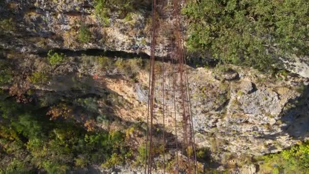 Un video aereo. Un vecchio ponte di corda metallica attraverso il canyon del fiume Moraca in Montenegro — Video Stock