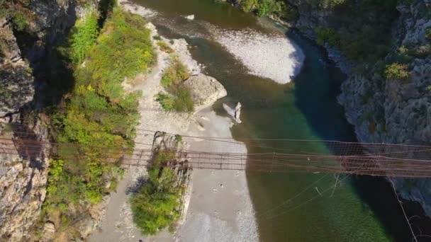 Vídeo aéreo. Un viejo puente de cuerda metálica sobre el cañón del río Moraca en Montenegro — Vídeo de stock