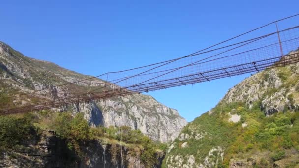 Nagranie z powietrza. Stary metalowy most linowy przez kanion rzeki Moraca w Czarnogórze — Wideo stockowe