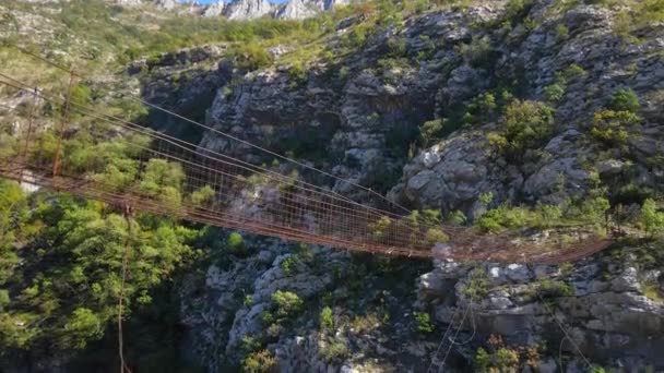 Nagranie z powietrza. Stary metalowy most linowy przez kanion rzeki Moraca w Czarnogórze — Wideo stockowe