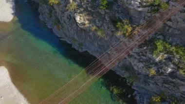 Hava videosu. Karadağ 'daki Moraca nehri kanyonu üzerinde eski metal bir ip köprü