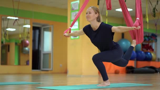 一位年轻女子使用特殊的吊床练习空中瑜伽 — 图库视频影像