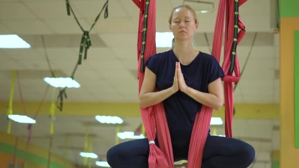 一位年轻女子使用特殊的吊床练习空中瑜伽 — 图库视频影像