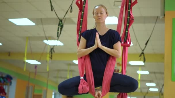 Een jonge vrouw oefent luchtyoga met behulp van speciale hangmatten — Stockvideo