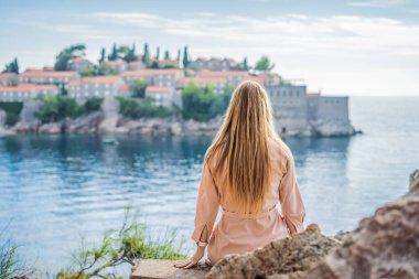 Karadağ 'ın Budva Riviera kentindeki St. Stephen adasının güzel manzaralı kadın turist Sveti Stefan. Karadağ 'a Seyahat