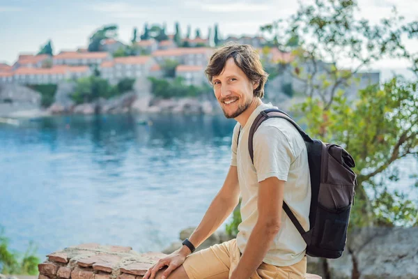 Hombre turista en el fondo de hermosa vista de la isla de San Esteban, Sveti Stefan en la Riviera de Budva, Budva, Montenegro. Viajes a Montenegro concepto —  Fotos de Stock