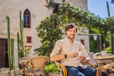 Genç turist, eski Budva kasabasında kahve içiyor. Karadağ 'a Seyahat