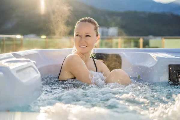 Portrait of young carefree happy smiling woman relaxing at hot tub during enjoying happy traveling moment vacation life against the background of green big mountains — Fotografia de Stock