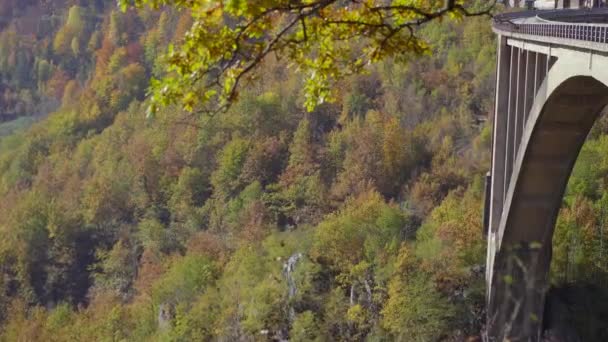 Ruční záběr nádherného mostu Djurdjevica přes kaňon řeky Tara v severní části Černé Hory. Zastřelen v podzimní sezóně. Koncept cestování do východní Evropy — Stock video