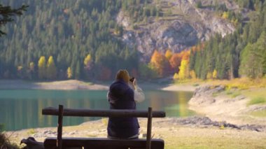 Genç bir kadın Crno Jezero 'yu ya da Zabljak yakınlarındaki Kara Göl' ü ziyaret eder. Gölün kenarındaki bankta oturan termostan sıcak su içiyor. Kuzey Karadağ 'a seyahat