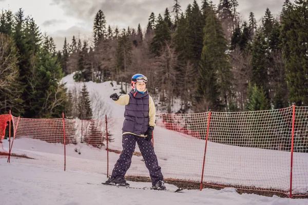 Kayak öğrenen bir kadın. Genç bir kadın dağlarda karlı bir yolda kayak yapıyor. — Stok fotoğraf