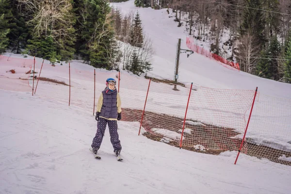 Жінка вчиться кататися на лижах. Молода жінка катається на лижах на засніженій дорозі в горах — стокове фото