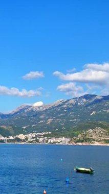 Dikey video. Karadağ 'ın Budva kenti yakınlarındaki Sveti Stefan adası yakınlarındaki bir körfezin panoramik görüntüsü